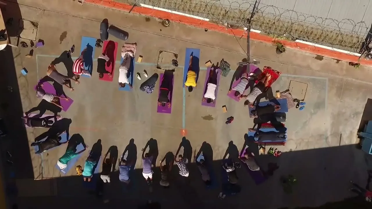 Vista aérea del patio de la Unidad 48: una clase de Moksha en ronda sobre los mats
